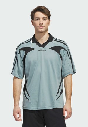 Jasnoszara sportowa koszulka polo z czarnymi akcentami i kołnierzem w kształcie litery V; krótkie rękawy z kontrastującymi bocznymi panelami. Widoczne logo marki.