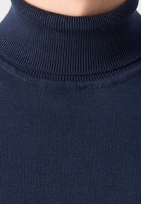 Navyblauer Rollkragenpullover aus weichem Stoff. Verfügt über einen gerippten Kragen und Körper, mit einer glatten Textur und enganliegendem Schnitt.