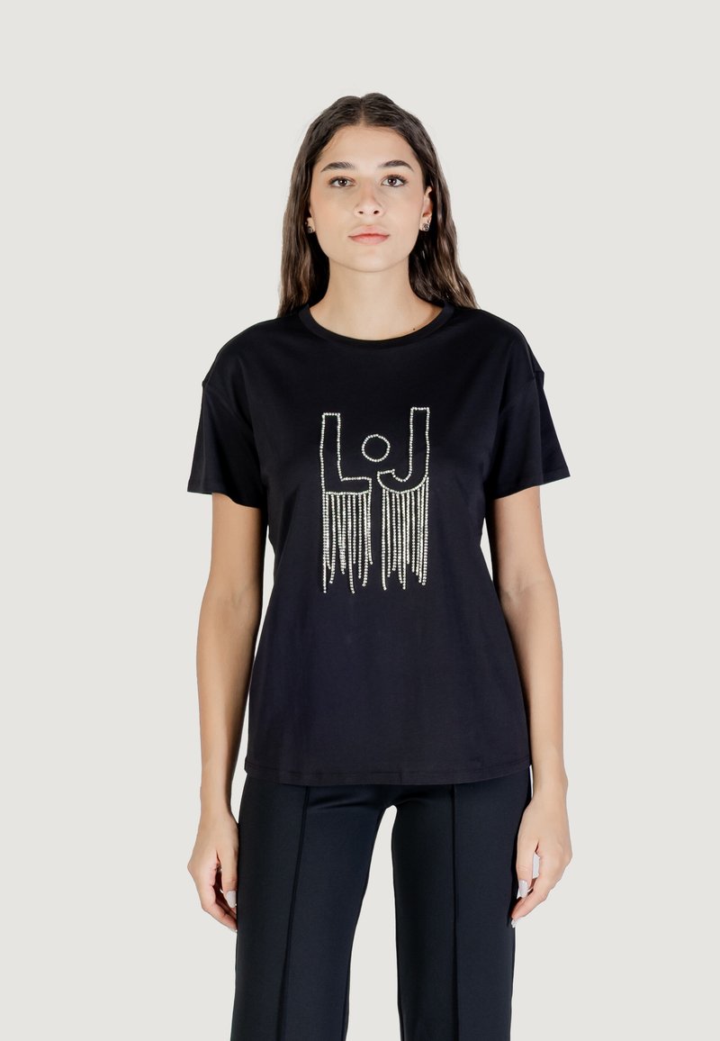 Camiseta de algodón negra de manga corta, con un diseño gráfico plateado "LJ" y detalles con flecos. Corte simple y relajado.