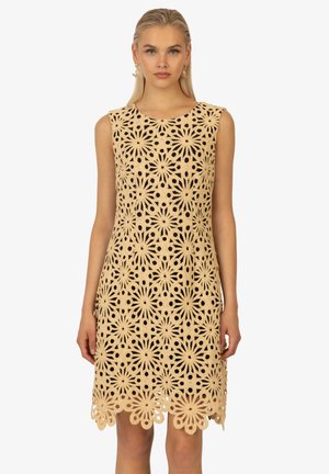 Spitzenkleid mit floralen Ausschnitten, beiger Farbe, ärmellosem Design, komplexem Muster und gewelltem Saum.
