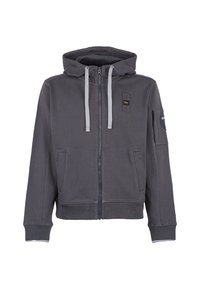 Felpa grigia con zip, dotata di cappuccio regolabile con cordino, due tasche anteriori e una tasca sulla manica. Presenta dettagli grigi a contrasto e una texture di stoffa morbida.