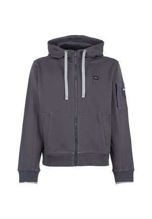 Felpa grigia con zip, dotata di cappuccio regolabile con cordino, due tasche anteriori e una tasca sulla manica. Presenta dettagli grigi a contrasto e una texture di stoffa morbida.