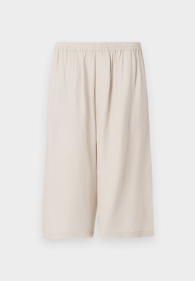 Beige shorts lavet af letvægtsstof, med elastisk talje, knælængde og glat tekstur. Simpelt design uden mønstre.