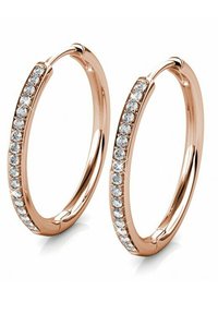 Orecchini a cerchio in oro rosa con una fila di cristalli trasparenti luccicanti lungo il bordo esterno; superficie liscia e lucida con forma circolare.
