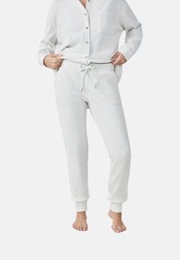 Grijze geribbelde loungewear set met een knoopsluiting top en een broek met koord. Zachte textuur, relaxed fit en taps toelopende boorden bij de enkels.