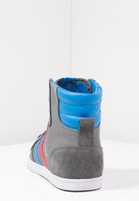 Høj-sneakers i gråt ruskind og stof med blå polstret krave, røde striber og hvid gummisål. Har teksturerede detaljer og syninger.