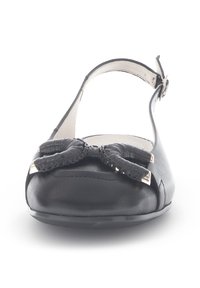 Zwarte leren platte schoen met een verstelbaar enkelbandje, voorzien van een grote geweven strik op de teen en metallic accenten aan de zijkanten.