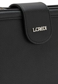 Borsa a tracolla in pelle nera con chiusura a linguetta magnetica; presenta un accento del logo metallico in argento. Superficie liscia e design elegante.