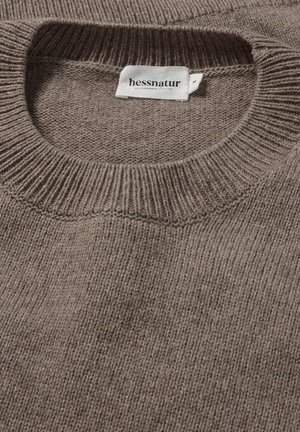 Bruine gebreide trui met een geribde halslijn en een zachte textuur, voorzien van een zichtbaar merketiket "hessnatur" in het midden.
