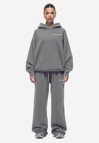 Grijze hoodie en sweatpants set gemaakt van zachte stof, met een ruime pasvorm, een voorzak en subtiele logo borduursels.