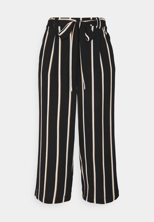 Pantalon large noir à rayures verticales blanches et beiges, taille haute, avec une ceinture nouée en tissu assorti à la taille.