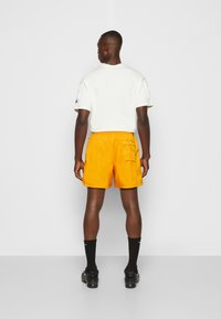 Nike Sportswear M NSW SPE WVN LND FLOW SHORT - Calças de fato de treino - kumquat/white