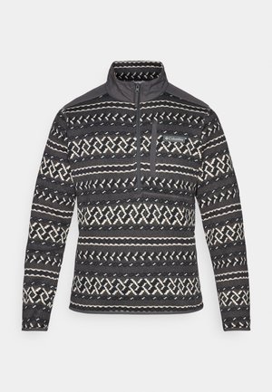 Schwarz-weiß gemusterter Fleece-Pullover mit Viertel-Reißverschluss-Kragen, ausgestattet mit einer Brusttasche und strukturierter Oberfläche. Markenlogo auf der Vorderseite.