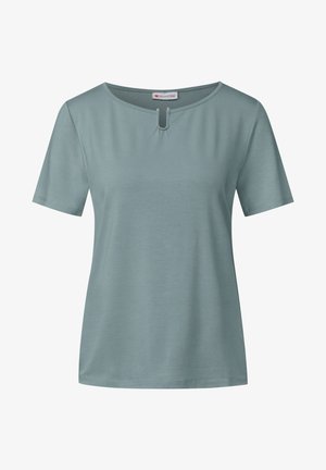 Lichtblauw t-shirt met korte mouwen van zachte stof, met een ronde halslijn met een kleine sleutelgat en metalen accentdetails in het midden.