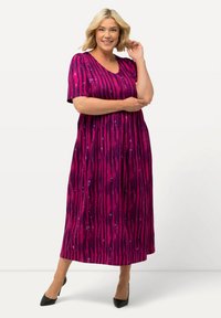 Fuksjowa sukienka do kolan z krótkimi rękawami, dekoltem w serek i marszczonym paskiem w talii. Posiada pionowy wzór w paski z cekinami.