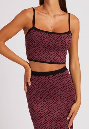 Bauchfreies Oberteil in Burgunderrot mit schwarzem geometrischem Muster, ausgestattet mit dünnen Trägern und einer taillierten Passform. Passender Rock mit ähnlichem Muster und schwarzem Bund.