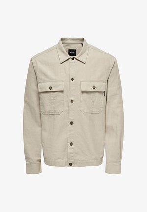 Veste beige à manches longues, fermeture avant par boutons, deux poches poitrine et un col. Fabriquée en tissu lisse avec un design décontracté.