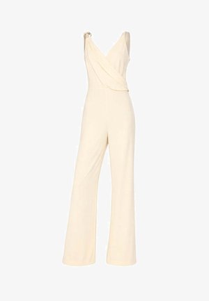 Tuta senza maniche color crema con gambe ampie, scollo a V incrociato e dettaglio con fibbia su una spallina.