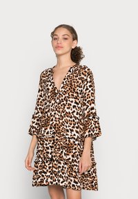 Vestido com padrão de leopardo, decote em V, mangas flare de três quartos e babados em camadas; tecido macio em tons de laranja, castanho e branco.