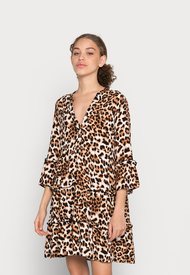 Vestido com padrão de leopardo, decote em V, mangas flare de três quartos e babados em camadas; tecido macio em tons de laranja, castanho e branco.