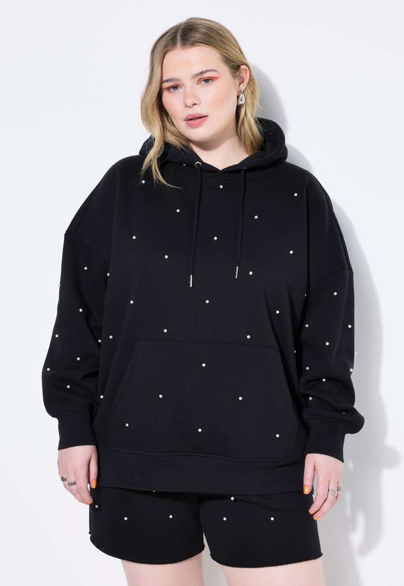 Sudadera negra con capucha y adornos blancos dispersos, que cuenta con un bolsillo frontal, mangas largas y un corte relajado.