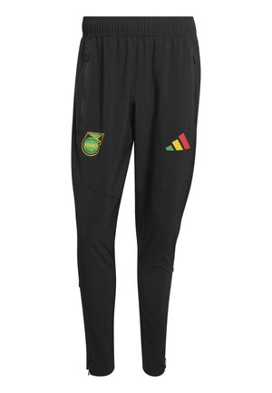 Pantalones deportivos negros con cintura elástica, bolsillos laterales con cremallera, escudo de la Federación de Fútbol de Jamaica en el muslo izquierdo y logo tricolor en el muslo derecho.