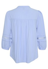 Blusa azzurra chiara con motivo testurizzato, colletto con bottoni e retro arricciato. Presenta maniche a tre quarti con rifiniture in pizzo.