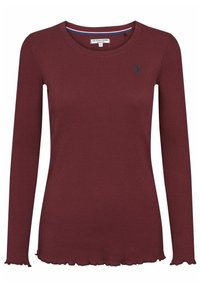Chemise bordeaux à manches longues, en ribbed, avec un col rond, un ourlet volanté et un petit logo bleu marine sur la poitrine gauche.