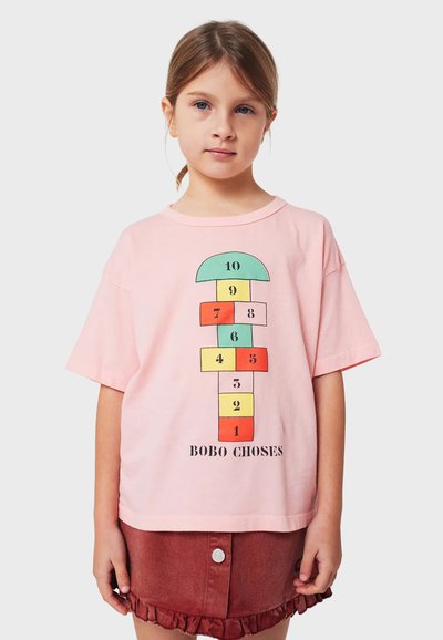Růžová bavlněná košile s barevným potiskem skákacího panáka s čísly a textem "BOBO CHOSES", krátké rukávy a volný střih.