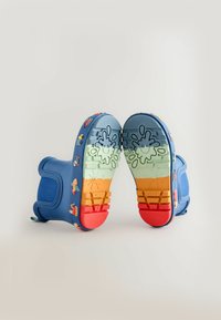 Blauwe rubberen laarzen met een getextureerd oppervlak. De onderkant heeft een multicolore zool en speelse karakterontwerpen, waaronder spetters en speelgoed.