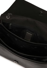 Interno di una borsa a tracolla nera in pelle, con una tasca con zip, materiale testurizzato e un pulsante di chiusura liscio. Rivestita con un motivo in tessuto con marchio.