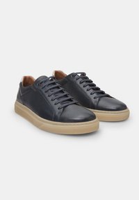 Navy blue leather sneakers with perforated accents, lace-up design, tan leather lining, and light gray rubber soles.