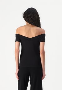 Černý top bez ramínek z měkké, elastické tkaniny s přiléhavým střihem a V-výstřihem vzadu. Krátké rukávy a elegantní silueta.