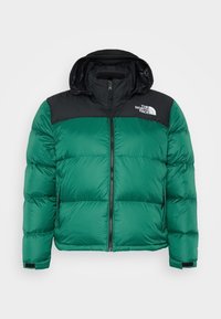 Zelená péřovka s černou kapucí na zip, vybavená zapínáním na zip vpředu, bočními kapsami a logem na levé horní části hrudi.