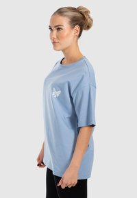 Lys blå kortærmet T-shirt i bomuld med afslappet pasform, prydet med en hvid sommerfugl broderi på forsiden. Glat tekstur, rund hals design.