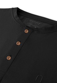 Schwarzes Langarmshirt mit Rundhalsausschnitt, ausgestattet mit vier Holzknöpfen und einem strukturierten Stoff. Das Etikett trägt den Markennamen "normani."