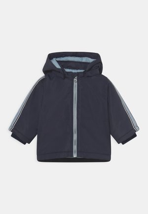 Marineblaue Kapuzenjacke mit durchgehendem Reißverschluss, hellblauem Innenfutter und Streifen an den Ärmeln. Wasserabweisendes Material, kurze Ärmel.