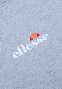 Tejido gris claro con el texto "ellesse" en blanco y un logo en medio círculo en naranja y rojo encima del texto.