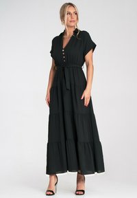 Czarna, warstwowa sukienka maxi z krótkimi rękawami, zapinana na guziki z wiązanym w pasie fasonem. Wykonana z lekkiego materiału o miękkiej fakturze i zwiewnym kroju.