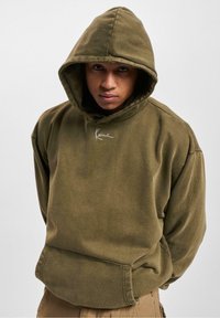 Sweatshirt à capuche vert olive avec une coupe décontractée, en tissu texturé, poche kangourou à l'avant et logo brodé blanc subtil au niveau de la poitrine.