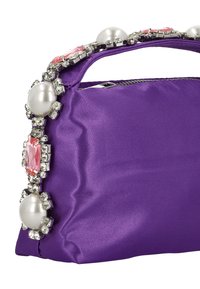 Lila szatén kézitáska strukturált formával, fogantyúja nagy műgyöngyökkel, rózsaszín és áttetsző drágakövekkel díszítve.