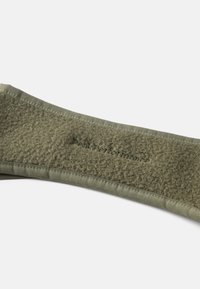 Bandeau en polaire vert avec un bord lisse, présentant un tissu texturé et un détail de logo en relief. Matériau doux et chaud conçu pour le confort.