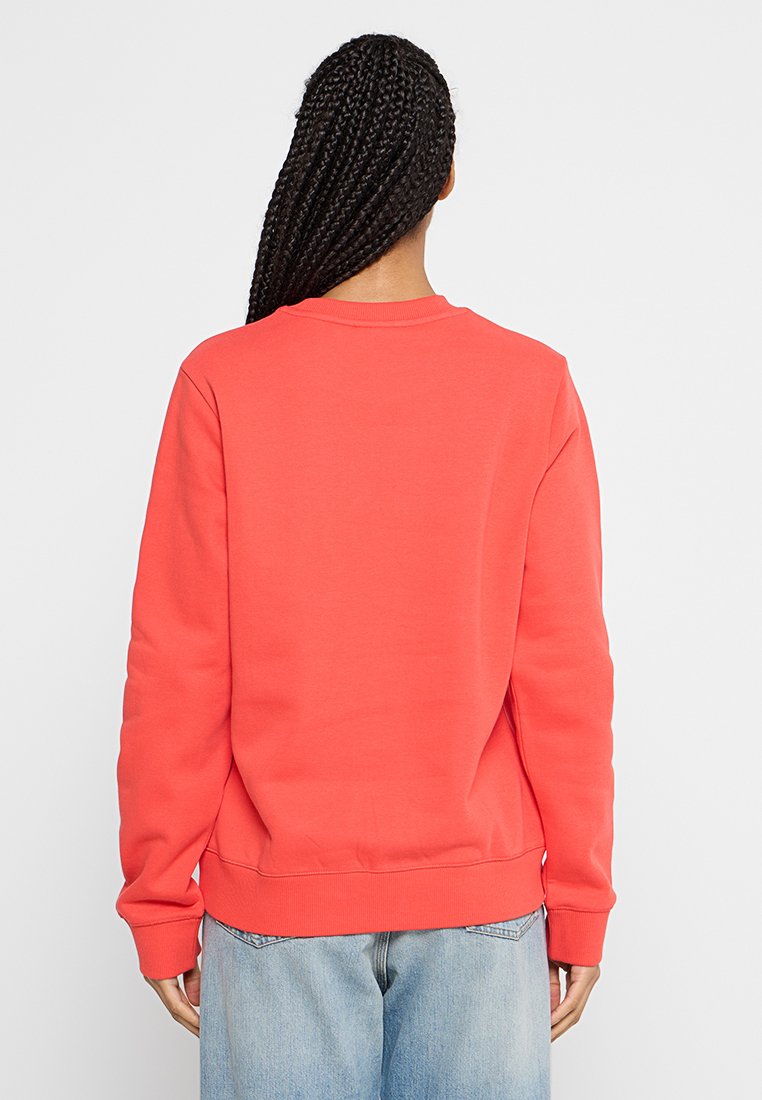 Korallenfarbener Sweatshirt mit langen Ärmeln, Rundhalsausschnitt und gerippten Bündchen. Weiche, glatte Textur, mit einem schlichten Design ohne sichtbare Logos oder Muster.