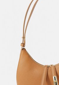 Tamsiai tekstūruota odinė rankinė su auksiniu užtrauktuku ir reguliuojama petneša ant balto fono.