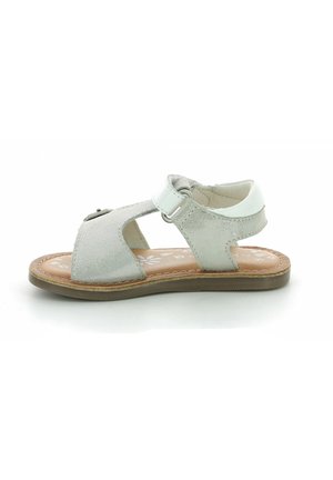 Sandalias de cuero gris con diseño de corte, correa ajustable con herrajes y una suela texturizada en color beige. Patrón de flores en la plantilla.