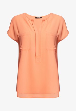 Blusa color pesco peach realizzata in tessuto leggero, caratterizzata da maniche corte, scollatura a V e due tasche sul petto con orlo dritto.
