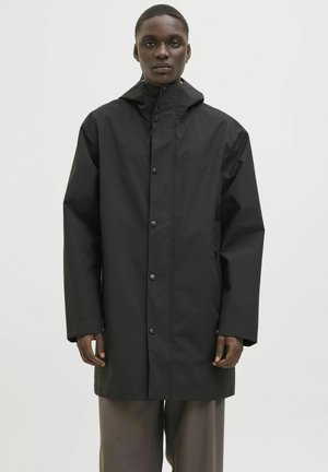 Veste noire imperméable avec fermeture éclair et boutons-pression, dotée d'un col haut et d'une capuche. Fabriquée en matériau lisse et léger.