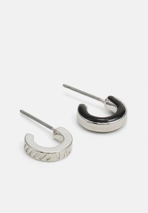 Metallringer i sølv og svart. Den ene ringen har et strukturert mønster; den andre har en glatt, blank overflate.