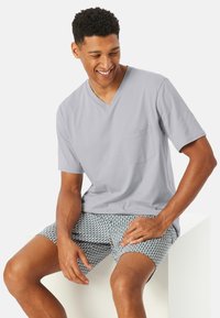 Gray v-neck t-shirt with short sleeves and a pocket, paired with patterned shorts featuring a wave design in blue and white.