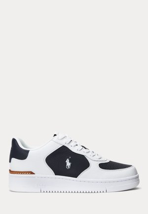 Baskets basses blanches et noires avec lacets, ornées d'un logo brodé cheval et cavalier sur le côté et d'une touche marron près du talon.